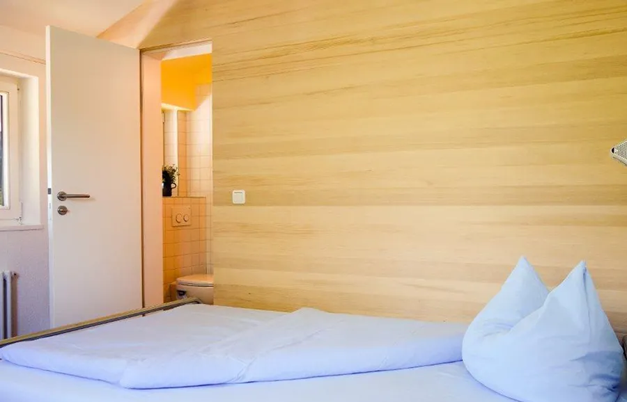 Zimmer mit Holzwand und eigenem Bad
